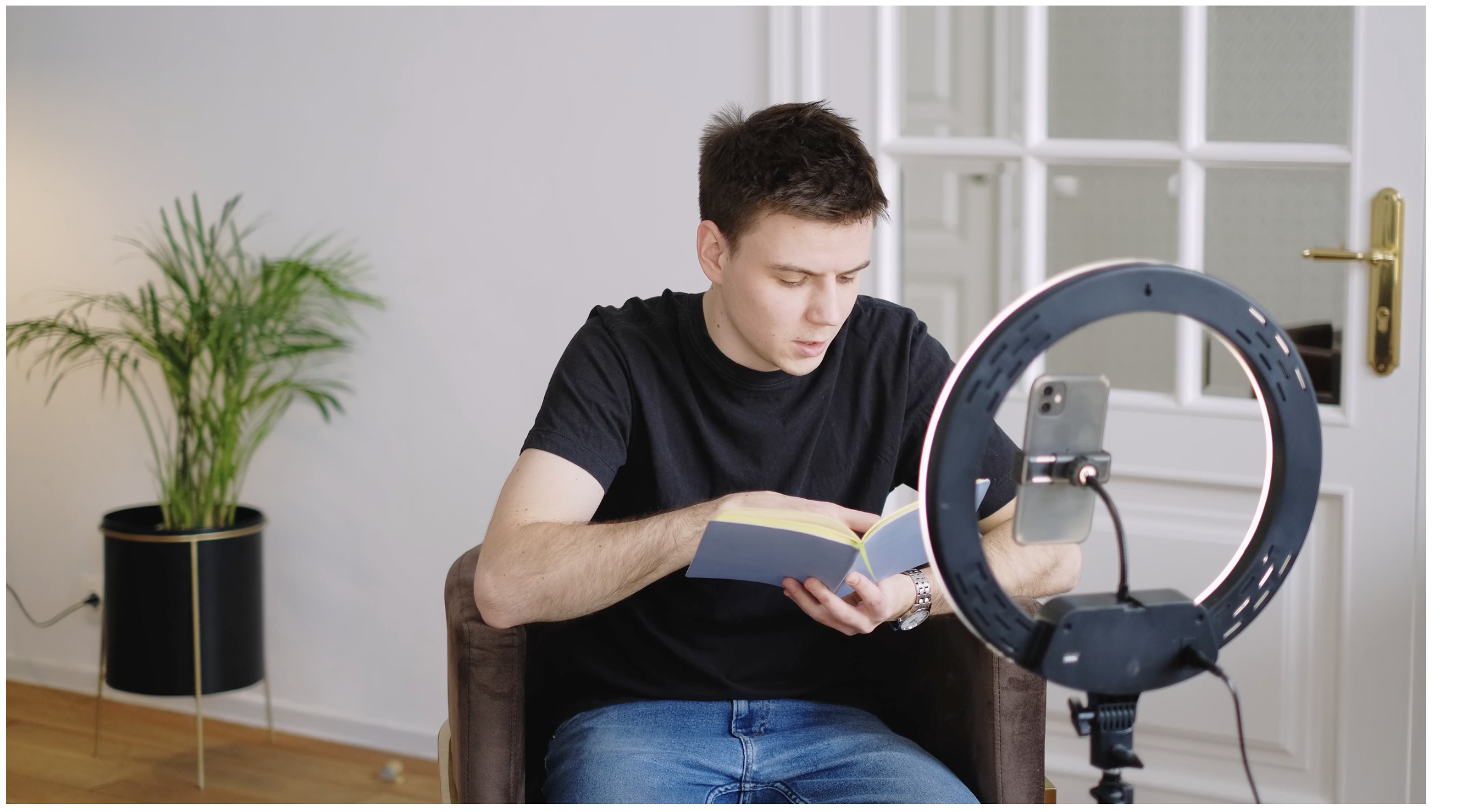 Image of a man creating content with a phone and a ring light