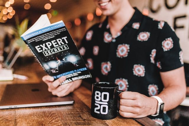 Image of man holding a book called expert secrets